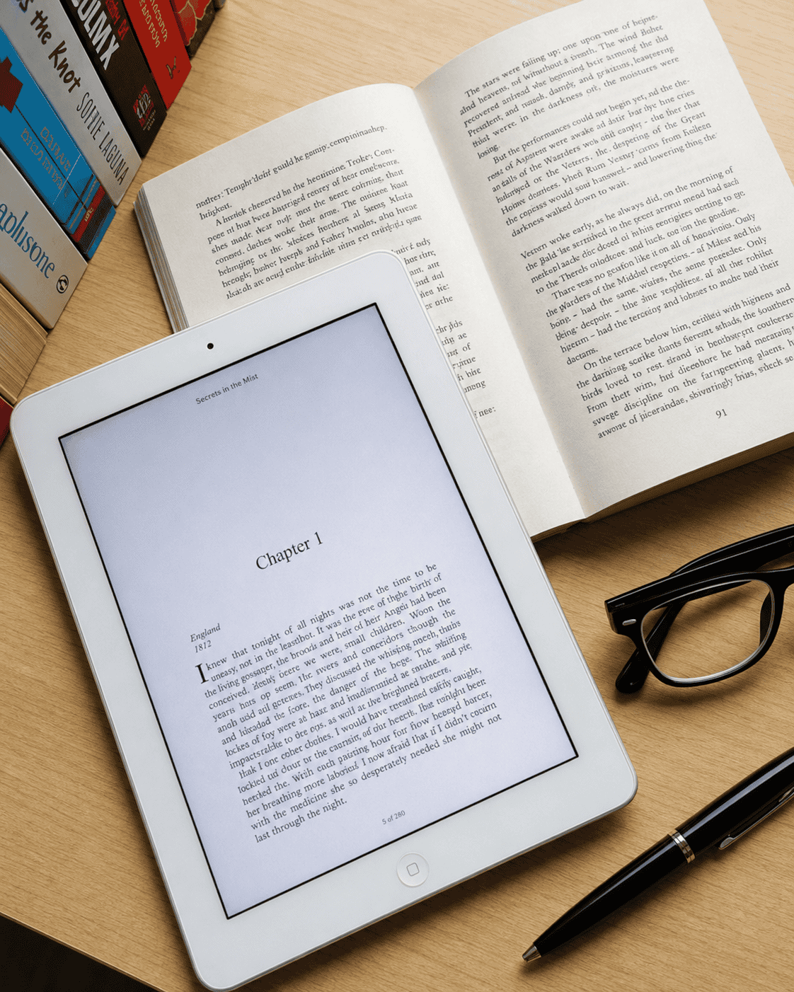 Open book and tablet displaying a manuscript