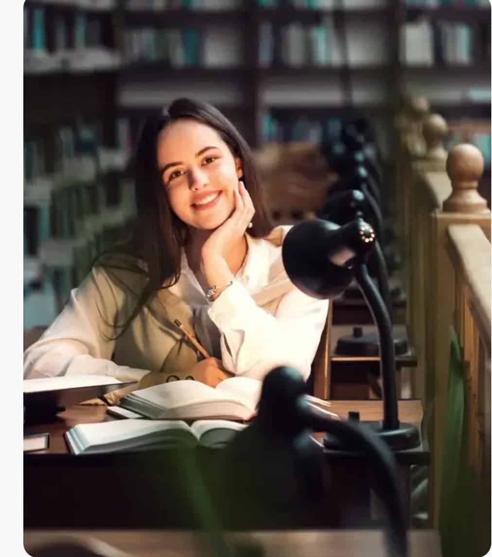 Woman sitting with books in a library