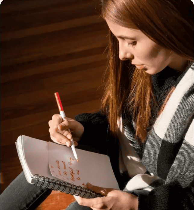 Woman writing creative ideas in a notebook